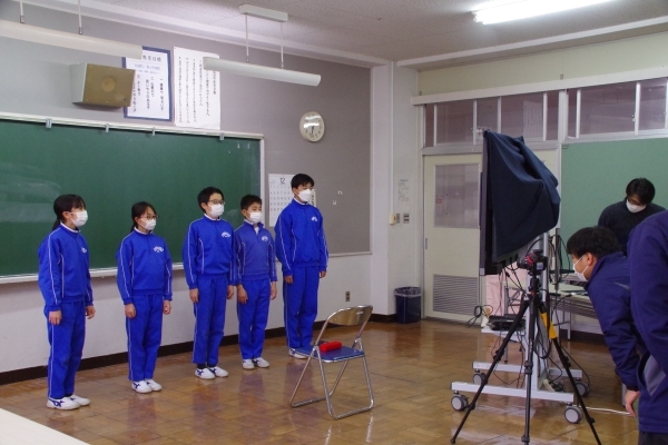 カメラの前に立ち発表する姿