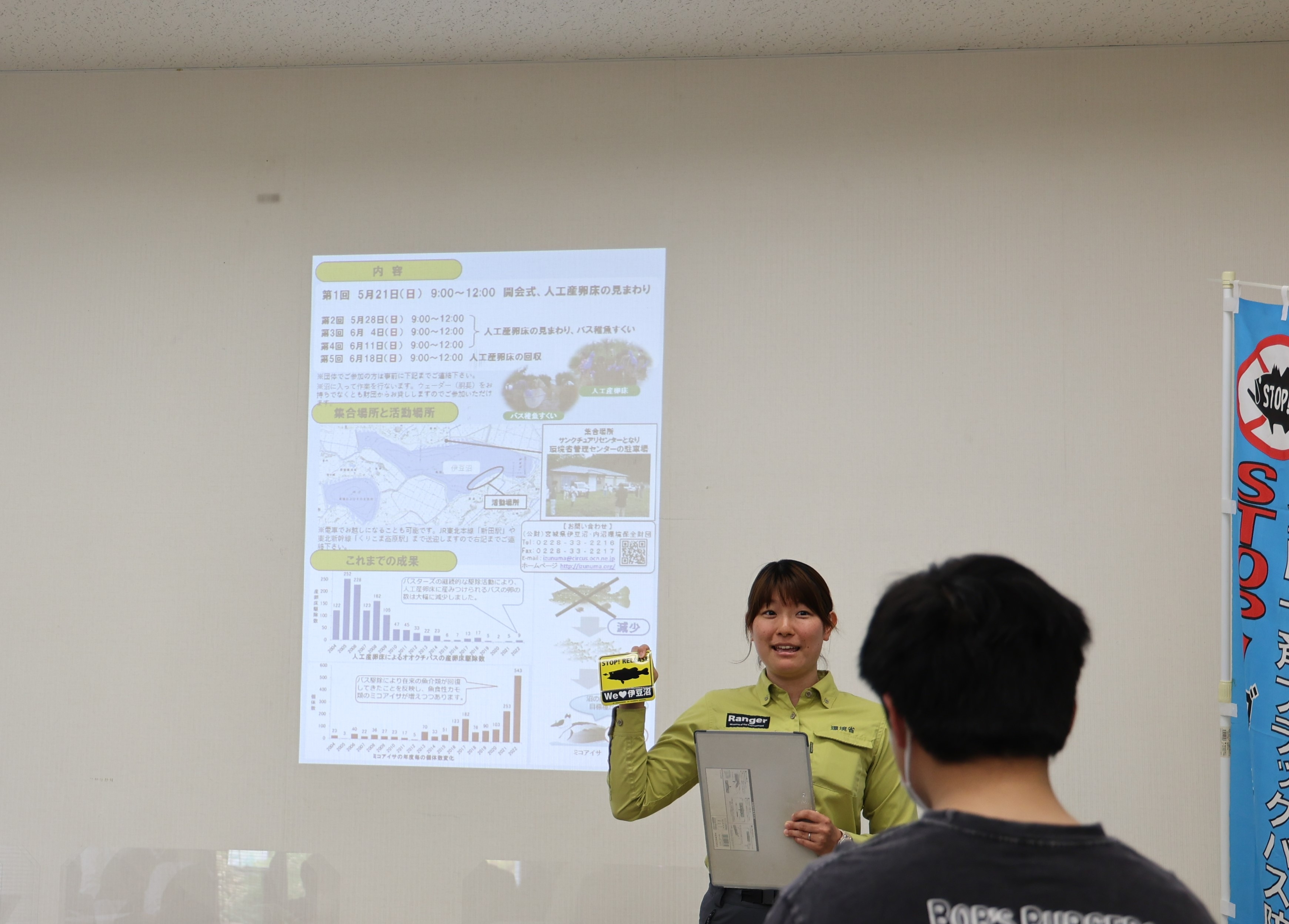 マグネットステッカーとクリアファイルを紹介する源関専門官