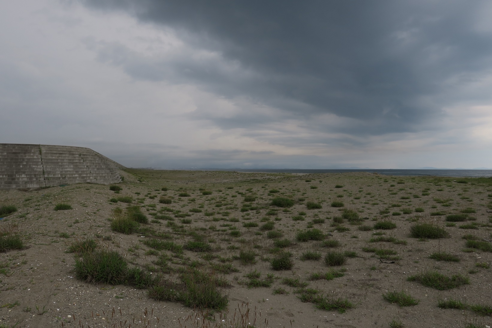 井土浦の防潮堤の突端の黒い雲